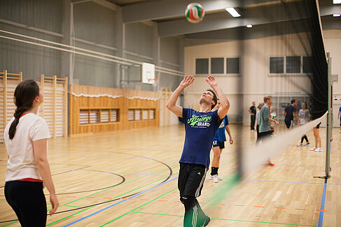 Zwei Studierende spielen Volleyball in der Sporthalle